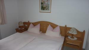 ein Schlafzimmer mit einem Bett mit weißen Laken und Kissen in der Unterkunft Fewo Ellen in Schönau am Königssee