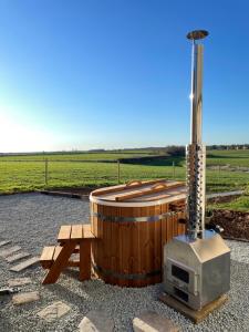 a hot tub with a tv and a bench at The Shepherds Retreat - Luxury Glamping in Patrington