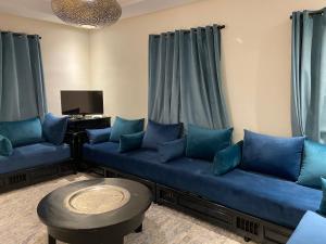 sala de estar con sofás azules y TV en Appartement coeur de médina en Taroudant