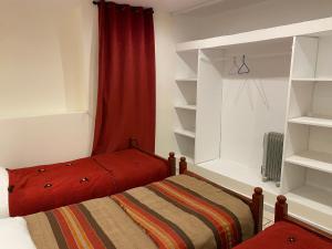 a bedroom with a bed and a red curtain and shelves at Appartement coeur de médina in Taroudant