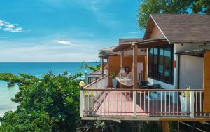 a house with a balcony overlooking the ocean at Chareena Hill Beach Resort in Ko Lipe