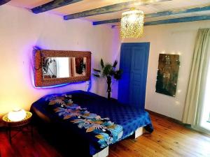 una camera con letto blu e specchio di A Casa Catalina B&B a Ucciani