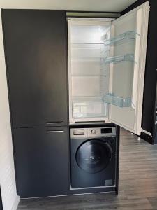 una cucina con frigorifero e lavatrice. di Paradise Garage a Hilvarenbeek
