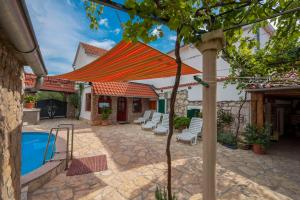 patio con ombrellone arancione e piscina di Stone house Morlako - with pool a Velika Čista