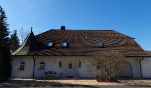 ein großes weißes Haus mit braunem Dach in der Unterkunft GardenView Apartments & Suites bei Bad Kissingen in Nüdlingen