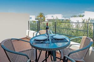 a table with a bottle of wine on a balcony at Palatia Village Hotel Apartments in Hersonissos