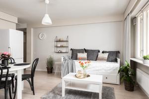 a white living room with a bed and a table at Apartments Borg Antinkatu in Pori