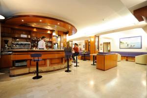 a bar in a hotel with two people standing at a counter at Hotel Adler in Alassio