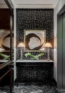 a room with a black wall with a picture and two lamps at Lotte Hotel Moscow - The Leading Hotels of the World in Moscow