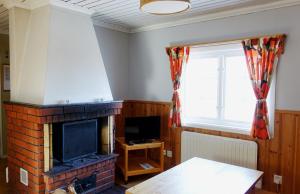 a living room with a fireplace and a television at Ekesberget Stugby stuga 10 in Ekshärad