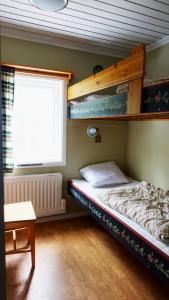 ein kleines Schlafzimmer mit einem Etagenbett und einem Fenster in der Unterkunft Ekesberget Stugby stuga 10 in Ekshärad