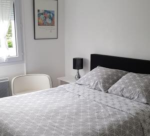 um quarto com uma cama com um edredão branco em Le Chat Bleu em Pont-Croix