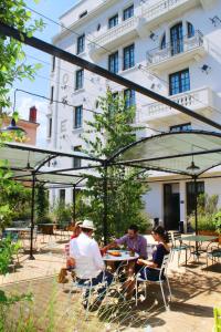 a group of people sitting at a table in front of a building at Collège Hôtel in Lyon