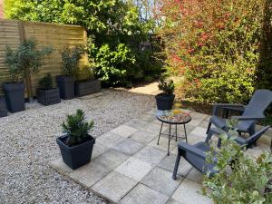 a patio with two chairs and a table and plants at À tire-larigot in Cousances-aux-Forges