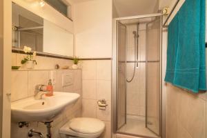 Un baño con lavabo, inodoro y ducha. en Haus Gigglberger, en Kressbronn am Bodensee 14 fotos más