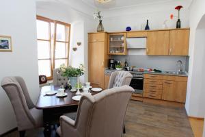 a kitchen with a wooden table and chairs at Ultra Alpes Ludwig Suite in Rottenbuch