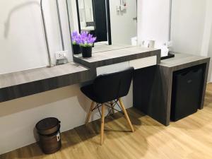 a desk with a chair in a room with a mirror at The Inka Hotel in Nakhon Si Thammarat