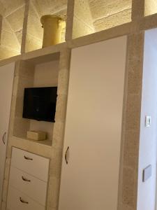 ein Raum mit einer Wand mit einem Fernseher und einem Regal in der Unterkunft Villa Ludovica in Ostuni