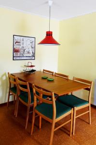 a dining room table with four chairs and a red light at Stuga Ekesberget Stugby in Ekshärad
