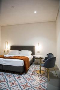 1 dormitorio con 1 cama, 1 mesa y 1 silla en 20 Miglia Boutique Hotel en Catania