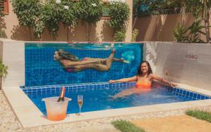 
a woman in a bikini sitting in a pool of water at Villa das Palmeiras in Jericoacoara
