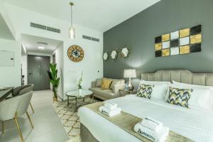 a bedroom with a bed and a living room at Primestay - Chic & Gorgeous studio in Al Barsha in Dubai