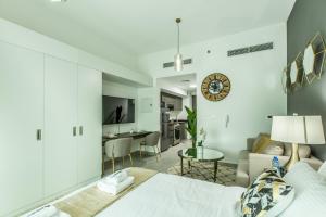 a bedroom with a bed and a living room at Primestay - Chic & Gorgeous studio in Al Barsha in Dubai