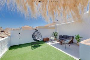 ein Wohnzimmer mit Sofa und Stühlen auf dem Balkon in der Unterkunft CASA TORRE Y SOL with big terrace & swimming pool in Torrevieja