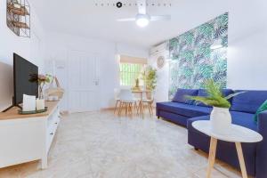 ein Wohnzimmer mit einem blauen Sofa und einem TV in der Unterkunft CASA TORRE Y SOL with big terrace & swimming pool in Torrevieja