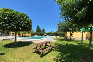 einen Picknicktisch im Gras neben einem Pool in der Unterkunft CASA TORRE Y SOL with big terrace & swimming pool in Torrevieja