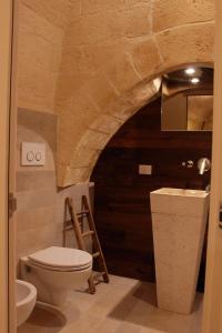 a bathroom with a toilet and a sink at Fondo Vito in Gravina in Puglia