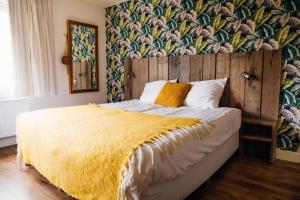 a bedroom with a bed with a yellow blanket at Fris. in Cadzand