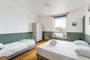 - une chambre avec 2 lits et une fenêtre dans l'établissement Le Hauturier - appartement de standing avec vue mer, à Saint-Malo