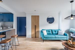 sala de estar con sofá azul y cocina en Le Cap Cézembre - Intra-Muros Saint-Malo, en Saint-Malo