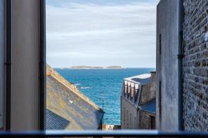 Elle offre une vue sur l'océan depuis sa fenêtre. dans l'établissement Le Cap Cézembre - Intra-Muros Saint-Malo, à Saint-Malo