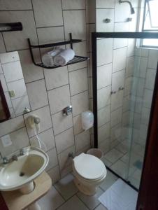 a bathroom with a shower and a toilet and a sink at Harbor Inn Jaraguá in Jaraguá do Sul