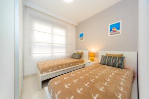 sypialnia z dwoma łóżkami i oknem w obiekcie Luxurious 2 Bedroom Apartment near the beach w mieście La Horadada