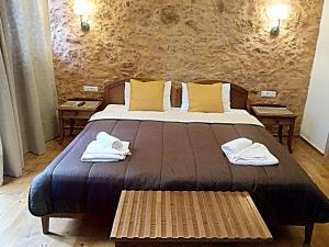 a bedroom with a large bed with towels on it at Santrivani Rooms in Chania