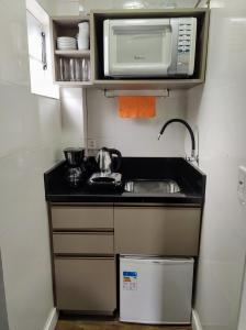 a small kitchen with a sink and a microwave at Viver a Natureza in Canela