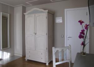 a white room with a white dresser and a wooden table at Hotel Migal in Cue
