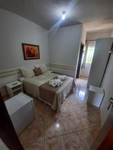 a bedroom with a bed and two tables in it at Pousada Guinda DIAMANTINA -MG in Diamantina