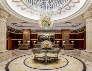 a large lobby with a chandelier and a table at Lotte Hotel Moscow - The Leading Hotels of the World in Moscow