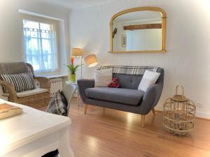 a living room with a couch and a mirror at La Belle Demeure in Saint-Cybranet