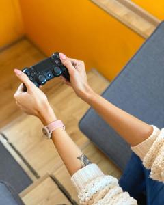 a woman playing a video game with a controller at Friday Hostel in Odesa