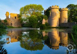 a castle with its reflection in the water at Wisteria Cottages are self catering cottages in a beautiful village location in Dorrington