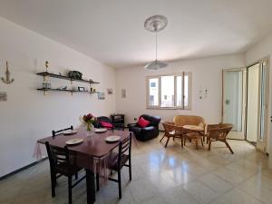 sala de estar con mesa y sillas en Casa Vittorio a 100m dalla Sabbia, en Lido Marini