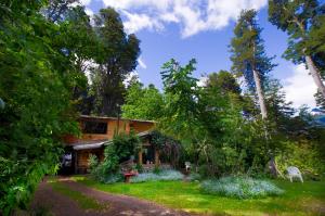 una casa en medio de un patio con árboles en la casa del sol en San Carlos de Bariloche