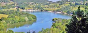 a river with boats on it in a valley at chalets19hameauxduperrier.com in Lissac-sur-Couze