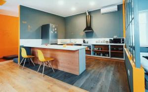 a kitchen with a counter and two yellow chairs at Friday Hostel in Odesa