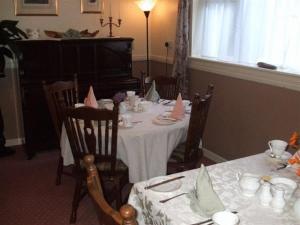 uma sala de jantar com uma mesa com cadeiras e um piano em Windway House em Killarney